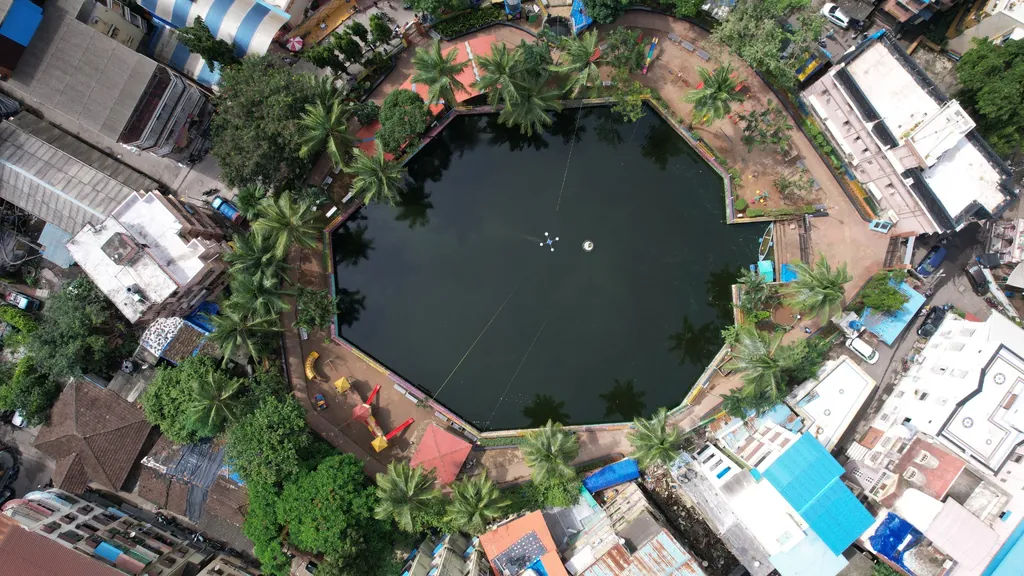 Aerial view of Rao Talao, Mira Bhayandar, during the ongoing project, with darker water and a floating unit mid-lake